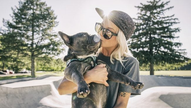 Femme seule au skatepark embrassant son chien