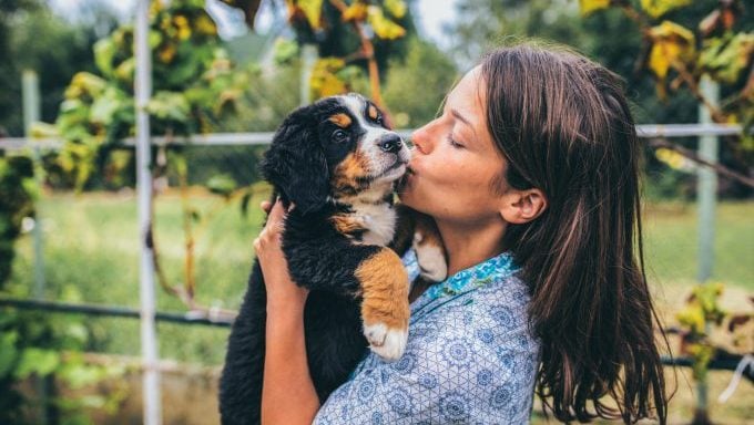 femme embrassant un chiot les meilleures et les pires raisons d'adopter un chien