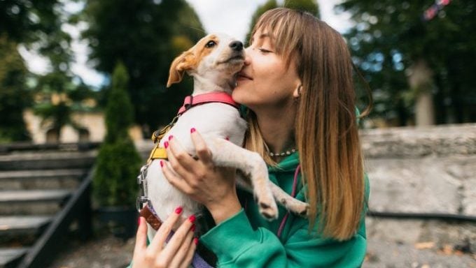 jeune femme embrassant son chien pourquoi les chiens sont mieux que les enfants