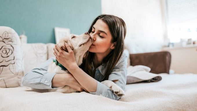 jeune femme serrant un chien dans ses bras